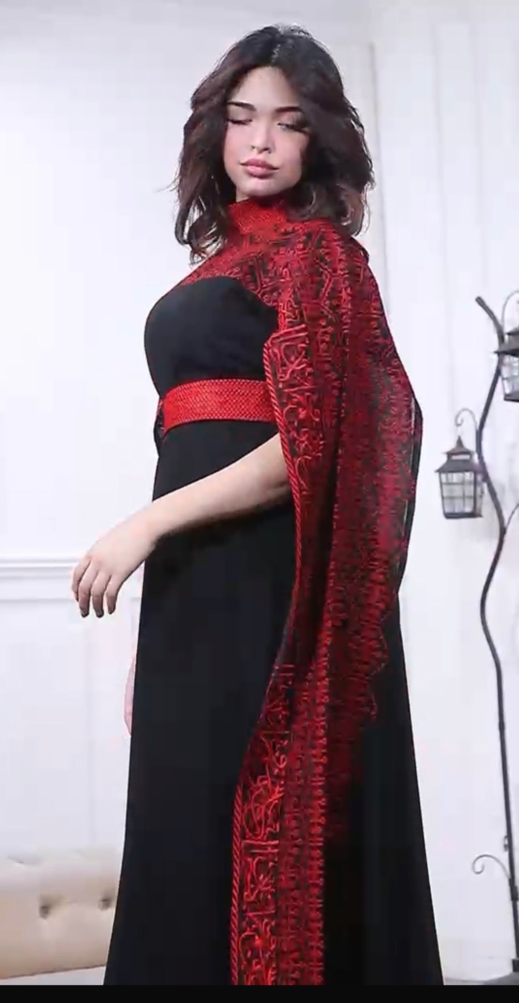 ثوب السنبلة Sonbula dress
Elegant black maxi dress with a stunning red embroidered high neck and dramatic cape sleeves. Designed with a matching red waist belt and a flowing silhouette, this gown is perfect for weddings, evening events, and special occasi